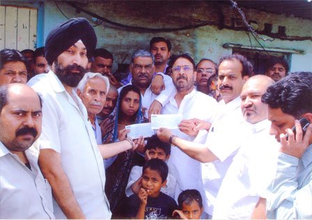 Sh. J.s Nayol, Sh.Rajesh Yadav and D.S Gill presenting relief cheques of Rs. 2 Lacs to residents of 